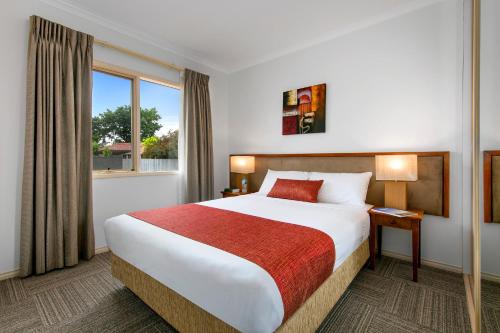 ein Hotelzimmer mit einem großen Bett und einem Fenster in der Unterkunft Quest Bendigo in Bendigo