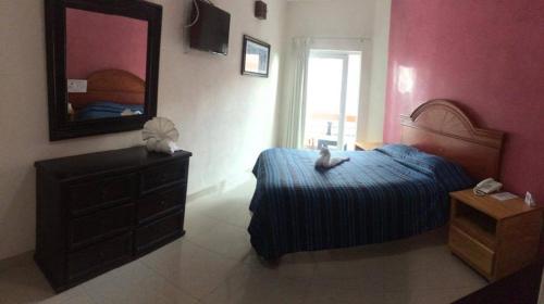 a bedroom with a bed and a dresser and a mirror at Casa del Parque Vallarta in Puerto Vallarta