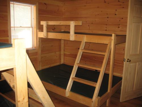 a bunk bed in a log cabin with a ladder at Okie Dokie Cabins in Tamworth