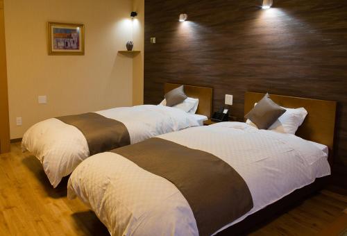 two beds in a hotel room with two at Oehonke in Kitami
