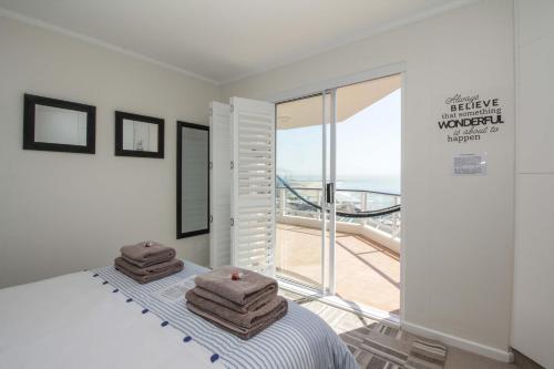 a bedroom with a bed with towels on it at Brookes Hill Executive Apartment in Port Elizabeth