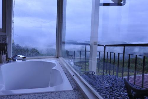 a bathroom with a bath tub in front of a window at View on View B&B in Puli