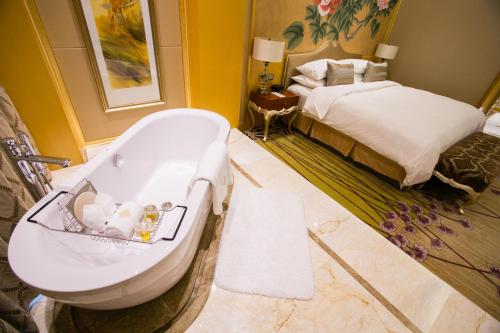 a bathroom with a bath tub and a bed at JinLing Hotel SanFangXiang in Jiangyin