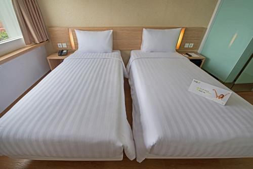 Postel nebo postele na pokoji v ubytování Whiz Prime Hotel Pajajaran Bogor
