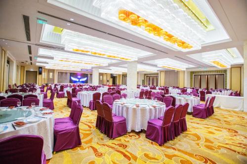 a banquet hall with white tables and purple chairs at JinLing Hotel SanFangXiang in Jiangyin