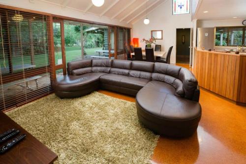 a living room with a leather couch and a table at Mt Glorious Getaways in Mount Glorious