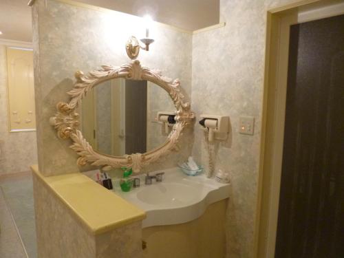 La salle de bains est pourvue d'un lavabo blanc et d'un miroir. dans l'établissement Hotel Sha La La, à Okinawa