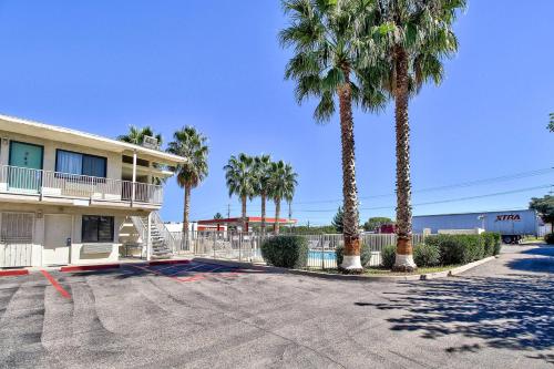 a parking lot in front of a building with palm trees at Motel 6-Nogales, AZ - Mariposa Road in Nogales