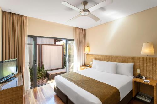 
a hotel room with a bed and a television at Kimberley Sands Resort in Broome
