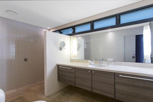 a bathroom with a sink and a large mirror at Kimberley Sands Resort in Broome