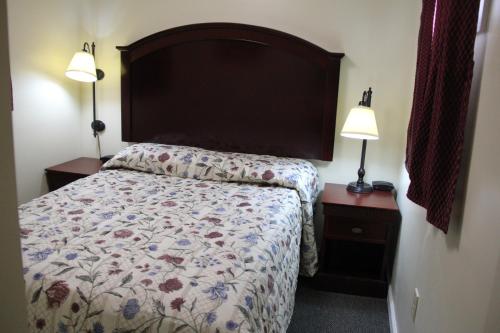 ミドルタウンにあるPleasant Hill Motelのベッドルーム1室(大型ヘッドボードとランプ2つ付)