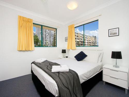 1 dormitorio con 1 cama y 2 ventanas en Aruba Surf Resort, en Gold Coast