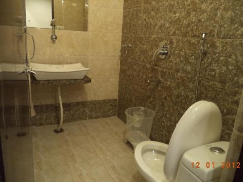 a bathroom with a sink and a toilet and a shower at Hotel Abhineet Palace in Jaipur