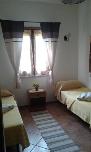 a bedroom with two beds and two windows at Casa Vacanze Campagna&mare in Pollina