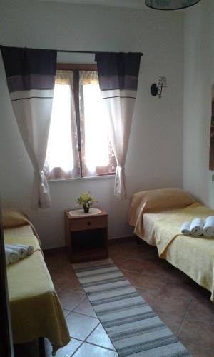 ポッリナにあるCasa Vacanze Campagna&mareのベッドルーム1室(ベッド2台、窓2つ付)
