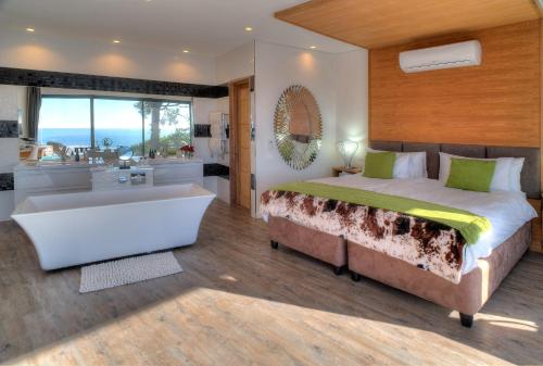 a bedroom with a large bed and a bath tub at Sea Star Rocks Boutique Hotel in Cape Town