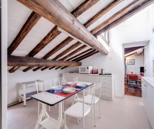 a kitchen with wooden ceilings and a table and chairs at AltanaParlamento in Rome