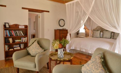 une chambre avec un lit, deux chaises et une table dans l'établissement De Hoop Collection Suites, à De Hoop Nature Reserve