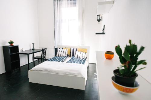 ブダペストにあるd.Five Stylish Apartment on Váci Streetのベッドルーム1室(ベッド1台、植物のあるテーブル付)