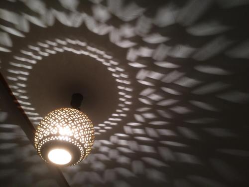 a chandelier with its shadow on a wall at Retreat wabi-sabi - walk to Ohama Beach - Max 12 ppl in Shimoda