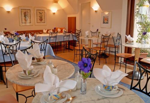 a banquet hall with tables and chairs with flowers on them at Stadthotel in Konstanz