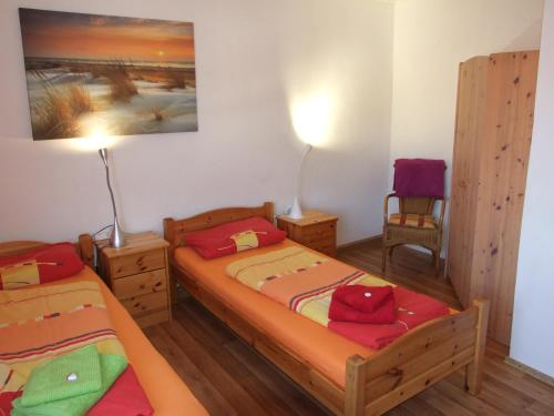 een slaapkamer met 2 bedden en een stoel bij Ferienwohnung Roth (Zentrum) in Roth