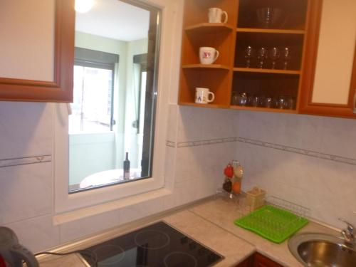a kitchen with a sink and a window at Apartman Ozi in Petrovac na Moru