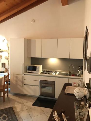 a kitchen with a stove and a microwave at Casella's Apartment in Malcesine