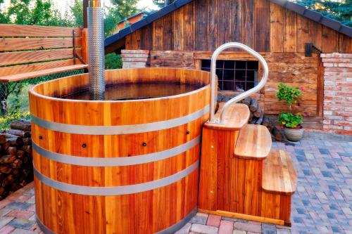a wooden hot tub in front of a wooden building at Vintage Home Vendégház in Miskolctapolca