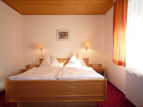 Schlafzimmer mit einem Bett mit weißer Bettwäsche und Kissen in der Unterkunft Appartement Bergkristall in St. Johann im Pongau