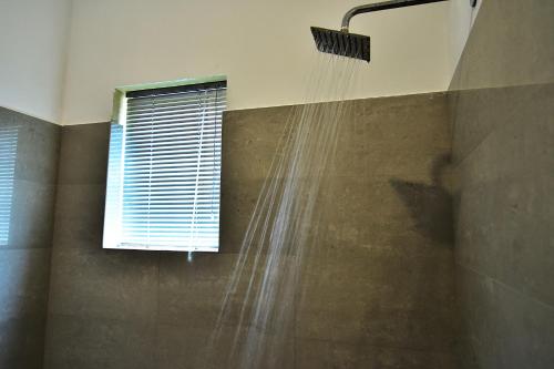a shower with water coming out of a window at Park Lane 88 Apartments in Negombo