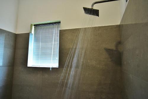 prysznic z wodą wychodzącą z okna w obiekcie Park Lane 88 Apartments w Negombo