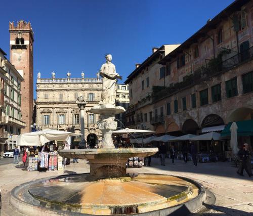 a fountain with a statue in the middle of a street at Hotel Gabbia D'Oro in Verona