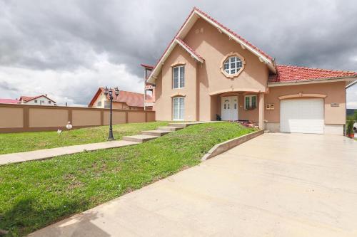 a house with a driveway in front of it at Casa Iulia in Haţeg