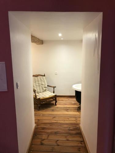 a hallway with a room with a chair and a tub at Mymoustiers in Moustiers-Sainte-Marie