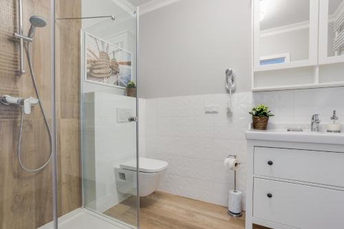 a bathroom with a shower and a toilet and a sink at Horyzont Luksusowe apartamenty nad morzem z parkingiem Międzyzdroje in Międzyzdroje