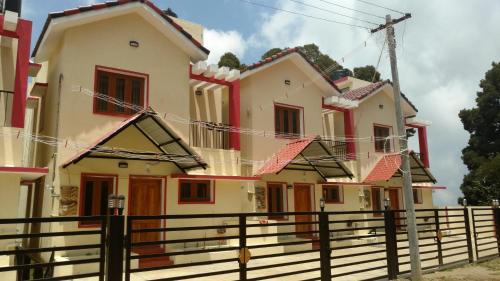 a row of houses with a fence in front at Pears Tree Duplex Villa in Kodaikānāl