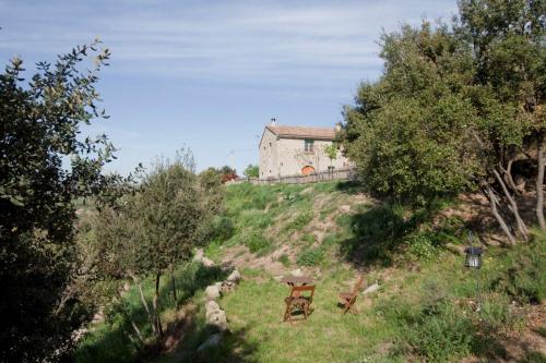 a house on top of a hill with two chairs at Cal Viudet Vell in Caserras