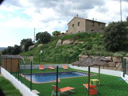 a house on top of a hill with a swimming pool at Cal Viudet Vell in Caserras