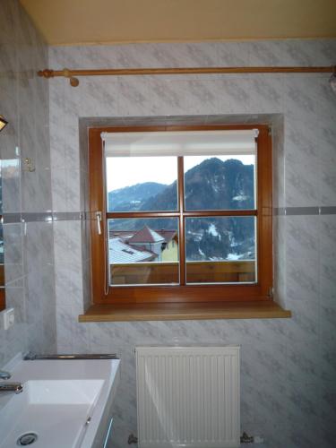 een badkamer met een raam met uitzicht op een berg bij Appartement Bergkristall in Sankt Johann im Pongau