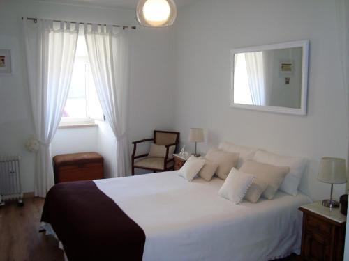 a bedroom with a large white bed with white pillows at Casa Vitorino's in Vale de Maceira