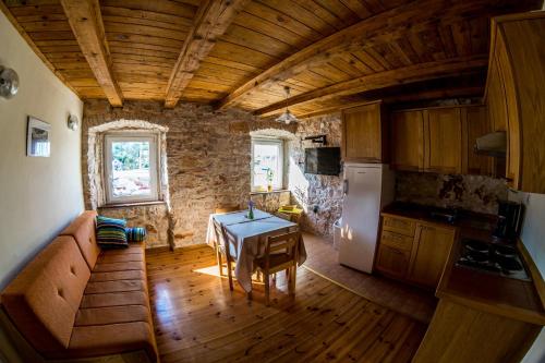 a small kitchen with a table and a refrigerator at Ducina Apartments in Milna