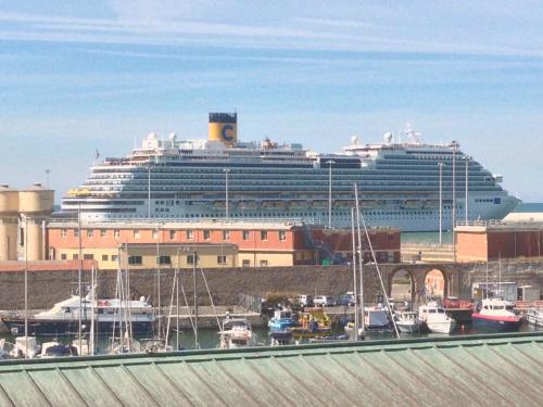 un crucero atracado en un puerto con barcos en Be Your Home - Guest House Fuori Dal Porto, en Civitavecchia