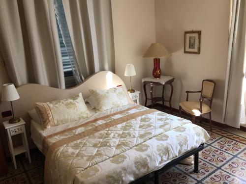 a bedroom with a bed and a chair and a window at Lucca Relais in Lucca