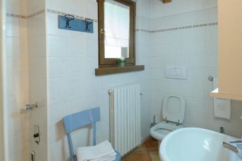 un bagno con lavandino, water e finestra di Residence Bait da Mott a Livigno