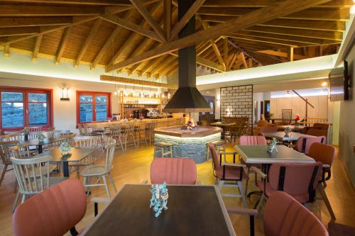 um restaurante com mesas e cadeiras e um bar em Rouista Tzoumerka Resort em Vourgareli