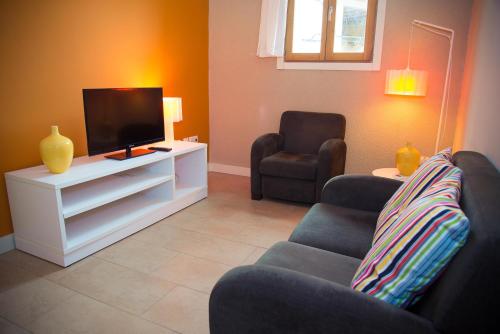 a living room with two couches and a flat screen tv at Apartamentos Bergantes in Ortells