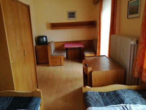 a small room with a small table and a television at Gasthof Kirchenwirt in Lackenhof
