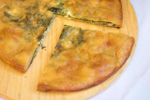 a slice of pizza on a wooden cutting board at Mira Mare Hotel, Galaxidi in Galaxidhion