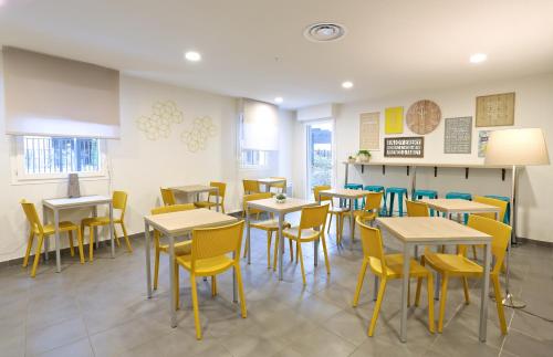 a dining room with tables and yellow chairs at Apparteo Marseille in Marseille